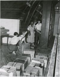 Maid, two workmen, and two other staff members packing books