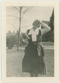 Girl standing on lawn with book in hand, smiling