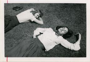 Two students lying on grass