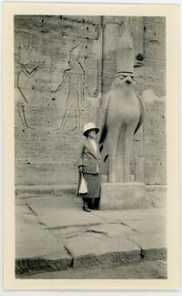 M. Carey Thomas standing next to giant bird statue and cave paintings