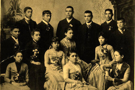Photograph of several graduates from the Carlisle Indian School dressed in a formal European style