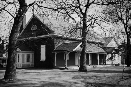 Black and white photograph of a Quaker meeting house and some trees in the winter