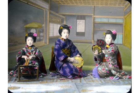 Three Japanese women in kimonos kneeling and handling various objects